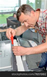 Man trying to repair the office printer