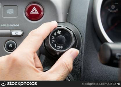 man turning car air conditioner switch
