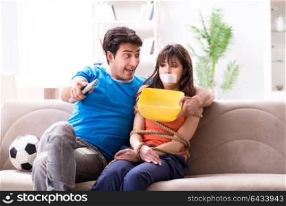 Man tying up his wife to watch sports football