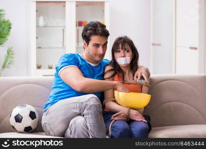 Man tying up his wife to watch sports football