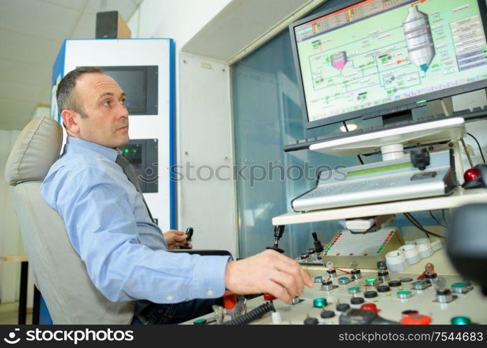 man typing at factory computer