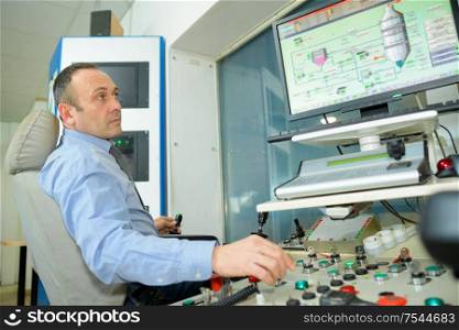 man typing at factory computer