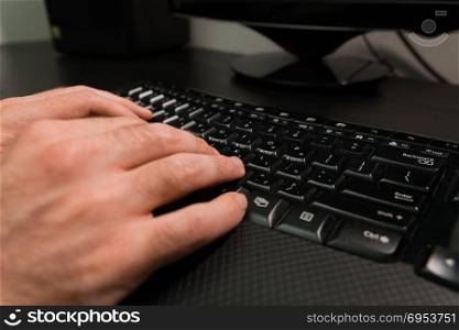 Man typing on a keyboard with letters in Hebrew and English - Wireless keyboard