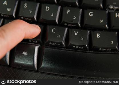 Man typing on a Wireless keyboard with letters in Hebrew and English - Press the Cut button - Top View