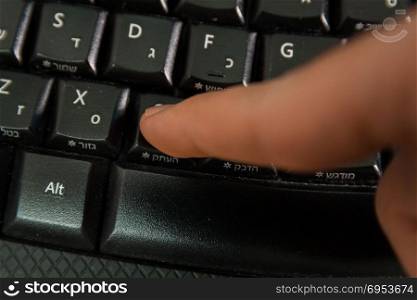Man typing on a Wireless keyboard with letters in Hebrew and English - Press the Copy button - Top View