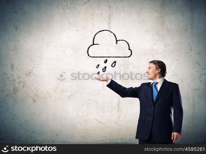 Man under rain. Young businessman holding palm to catch rain drops