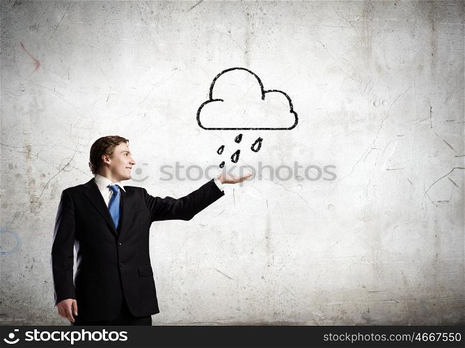 Man under rain. Young businessman holding palm to catch rain drops