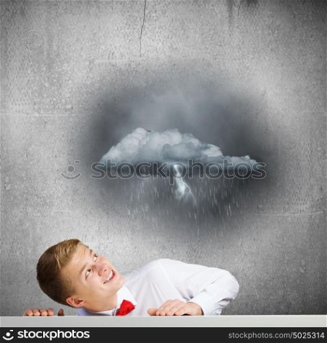 Man under rain. Young man looking above at raining cloud