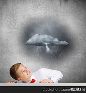 Man under rain. Young man looking above at raining cloud