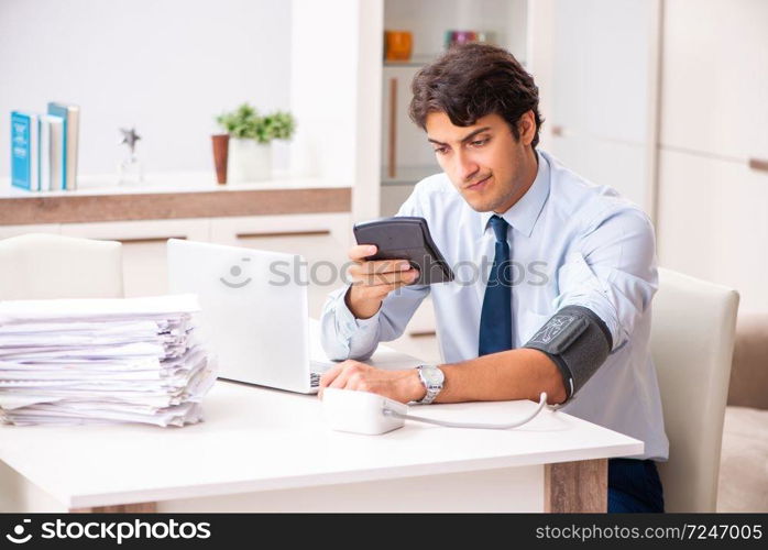 Man under stress measuring his blood pressure