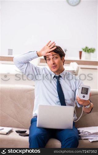 Man under stress measuring his blood pressure