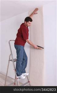 man upholstering a wall