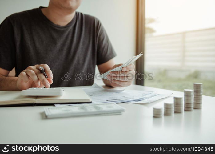 Man use calculators and documents that calculate expenses in the home office.