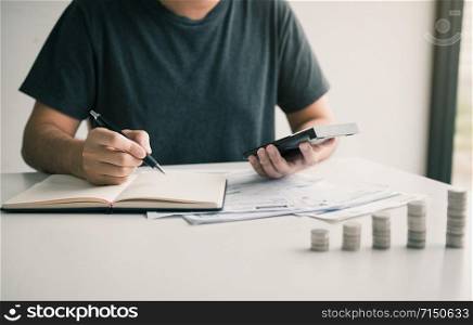 Man use calculators and documents that calculate expenses in the home office.