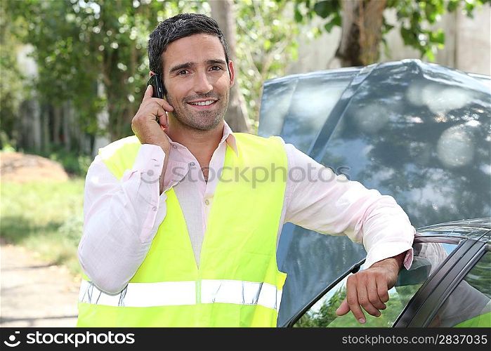 Man using a cellphone at a vehicle breakdown
