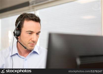 Man using a headset at a computer