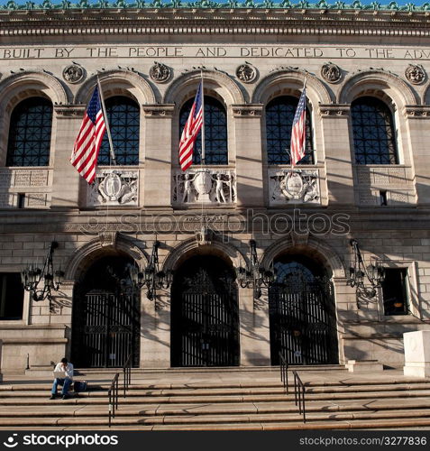 Man using a laptop in front of a building in Boston, Massachusetts, USA