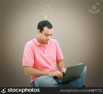 Man using a laptop with light bulb over his head