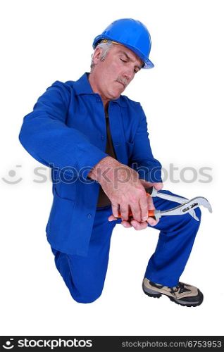 Man using a spanner on empty copyspace