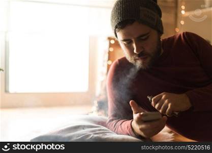Man using a vaper and smartphone - Winter and Christmas Season