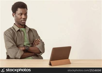 man using air pods looking digital tablet