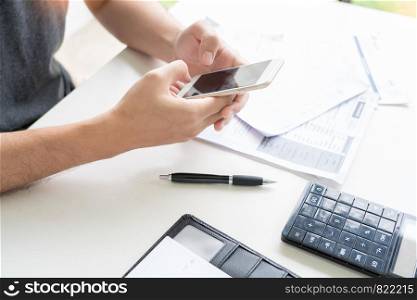 Man using calculator and calculate bills receipt in home expenses payments costs with paper note, financial account management and payment or saving concept