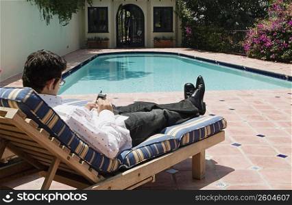 Man using cellular phone by poolside
