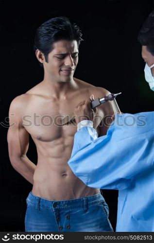 Man using chisel on muscular body