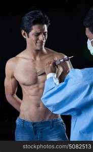 Man using chisel on muscular body