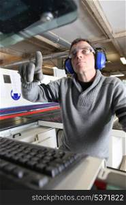 Man using computer controlled factory machine