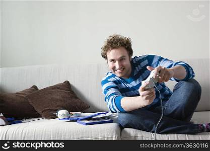 Man using computer game controls sitting on sofa