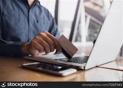Man using credit card with shopping online concept at cafe.