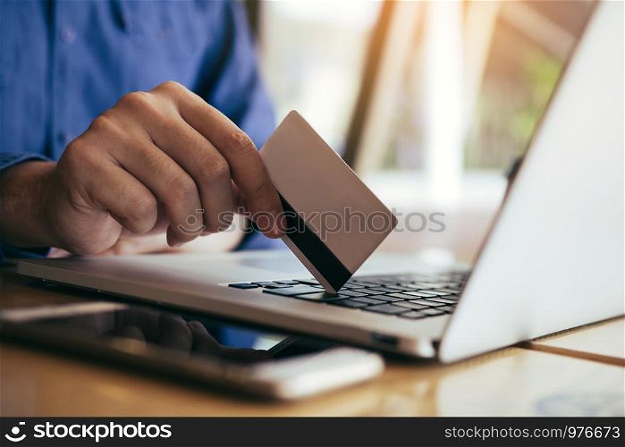 Man using credit card with shopping online concept at cafe.