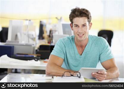 Man Using Digital Tablet In Busy Creative Office