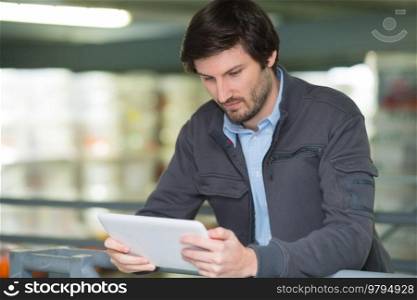 man using digital tablet in shop