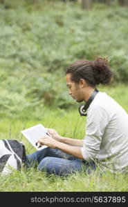 Man Using Digital Tablet Whilst Hiking In Countryside