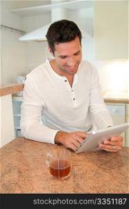 Man using electronic tablet in home kitchen