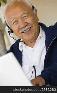 Man Using Headset and Laptop
