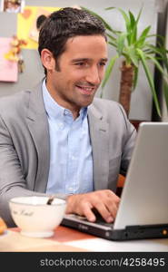 Man using his laptop during breakfast