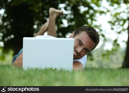 Man using his laptop on a lawn
