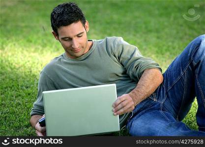 Man using his laptop on the grass