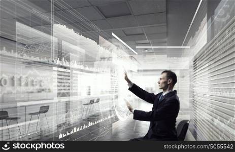 Man using innovative technologies mixed media. Businessman in chair working with virtual panel