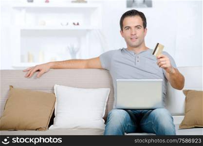 man using laptop and credit card to buy online