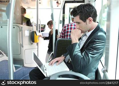 Man using laptop computer on a tram