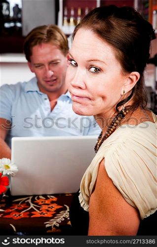 Man using laptop ignoring his date in coffee house