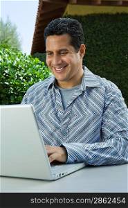 Man using laptop in back yard