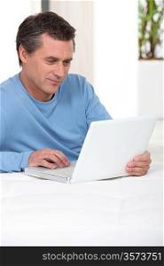 Man using laptop on his bed