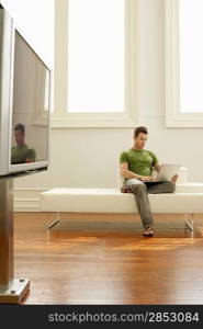 Man Using Laptop on Modern Sofa