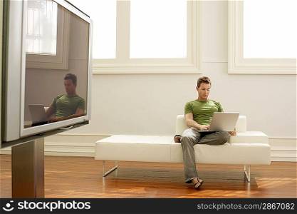 Man Using Laptop on Modern Sofa