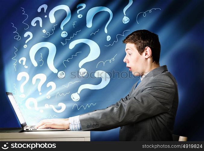 Man using laptop. Young businessman looking shocked into laptop monitor
